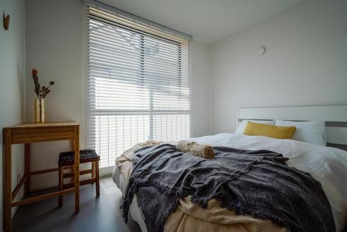 a bedroom with a large bed and a window at HOUS-AGALonomichi in Onomichi
