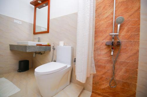 a bathroom with a toilet and a shower at Hotel Alakamanda in Anuradhapura