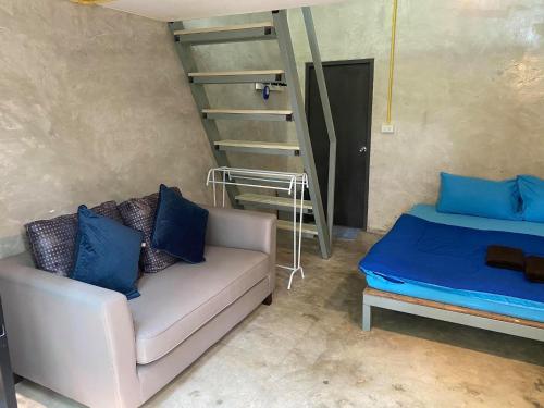 a living room with a couch and a staircase at BeachBox@Koh Сhang in Ko Chang