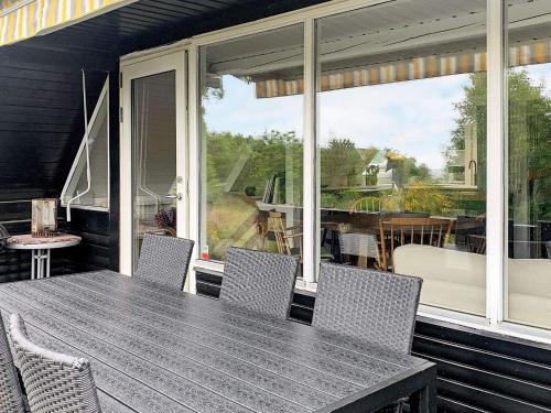 a screened in porch with a table and chairs at 5 person holiday home in Roslev in Roslev