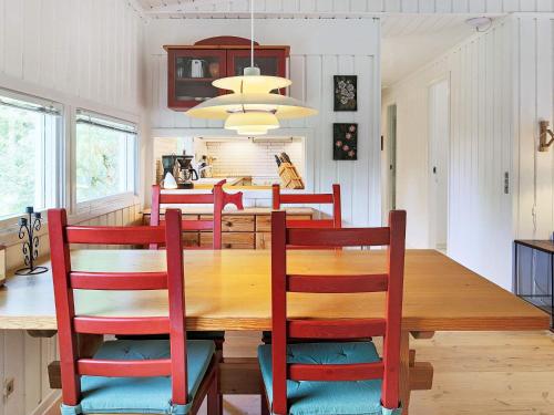 uma sala de jantar e cozinha com mesa e cadeiras de madeira em 4 person holiday home in Vejby em Vejby