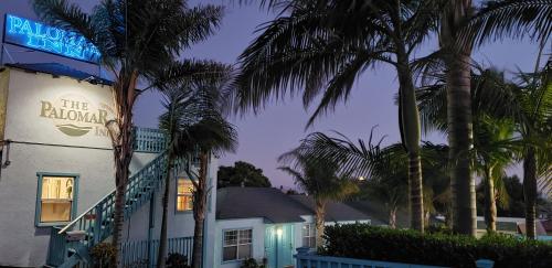 a building with palm trees in front of it at The Palomar Inn in Pismo Beach