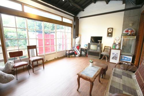 a living room filled with furniture and windows at Old Mamaboy Marines Hostel獨立包棟三間雙人雅房 in Kaohsiung