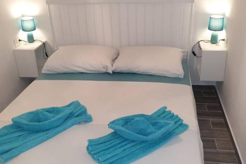 a bed with two blue towels on top of it at Apartman Opal in Čunski
