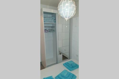 a bathroom with a mirror and a chandelier at Apartman Opal in Čunski