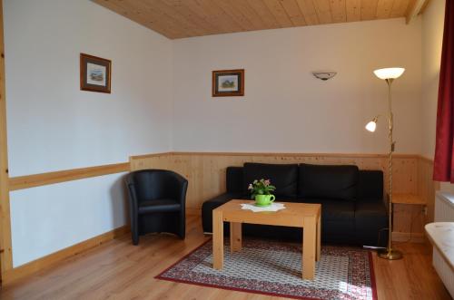 a living room with a couch and a table at Pension zum Schreiner in Hermagor