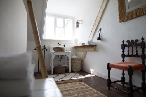 a bathroom with a window and a chair in a room at Liegen;schaft Guesthouse in Oestrich-Winkel