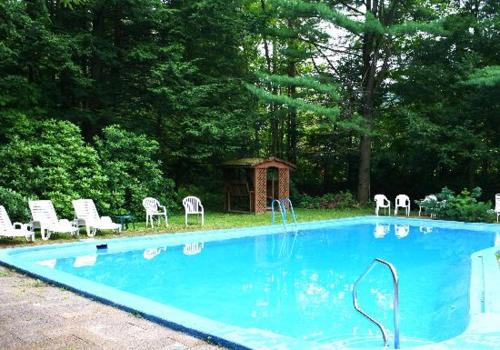 a swimming pool with chairs and a gazebo at Stay Berkshires in Williamstown