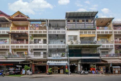 a tall white building with balconies on a street at The Artist Residence in Phnom Penh