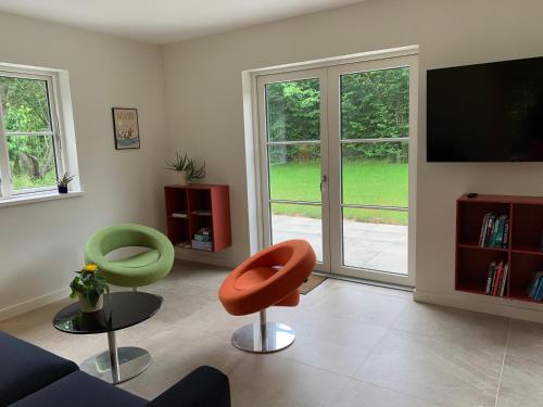 a living room with two chairs and a tv at Langø Feriecenter - Garden View in Nakskov