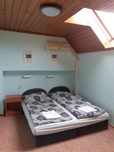 a bed in a room with a ceiling at Júlia Vendégház in Sárospatak