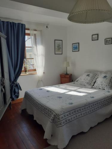 - une chambre avec un lit doté d'un rideau bleu et d'une fenêtre dans l'établissement Maison Normande, à Asnelles