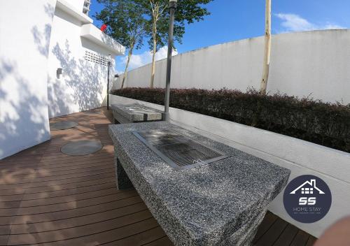 a bench sitting on a wooden deck next to a fence at KULAI HOME STAY @IOI MALL/JPO/AEON/SENAI AIRPORT in Kulai