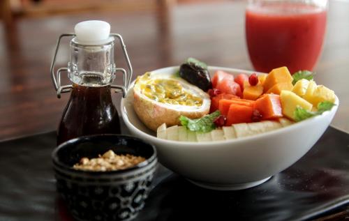 a plate of food with a bowl of fruit and a drink at Bay Vista in Arugam Bay