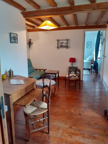 a living room with a wooden table and chairs at Maison Normande in Asnelles