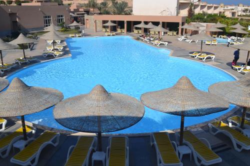 a large swimming pool with umbrellas and chairs at Vai by Romance Hotel & Aqua Park in Ain Sokhna