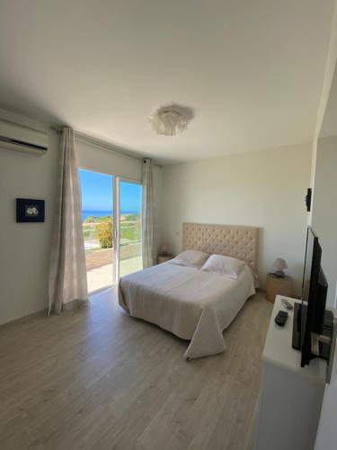 a bedroom with a bed and a large window at VIzzavona piscine et jacuzzi in Ajaccio