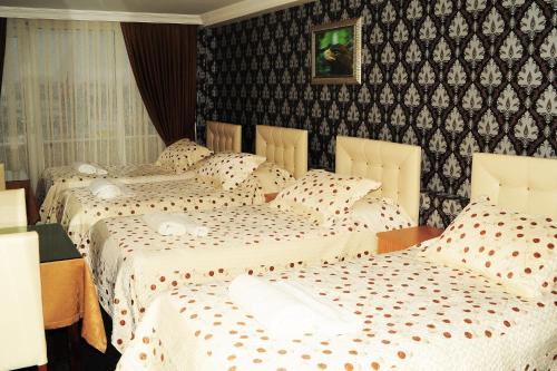 two beds in a hotel room with white sheets at Kervan Hotel Pendik in Istanbul