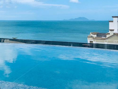 a large swimming pool with the ocean in the background at 210 B Espelho das Aguas in Florianópolis
