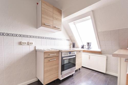 a small kitchen with a stove and a window at Ferienwohnung Hummelhus Elmenhorst in Elmenhorst