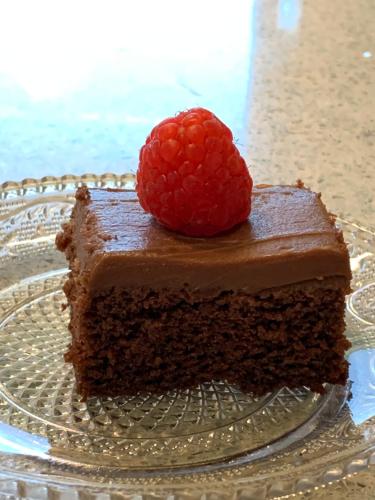 a piece of chocolate cake with a raspberry on a glass plate at B&B Beauty House in Cesena