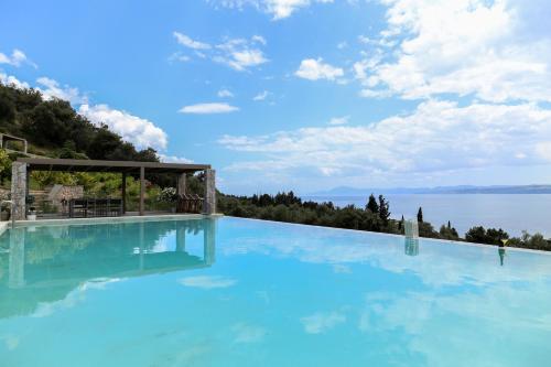a large swimming pool with a view of the water at Elimnion Resort in Khronia