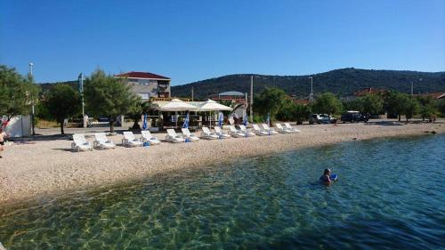 a person sitting in the water at a beach at Providenca in Vinišće