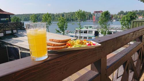 a glass of orange juice and a plate of food on a table at Apartamenty Twoje Mikołajki in Mikołajki