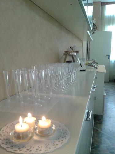 a row of wine glasses sitting on a counter with candles at Hotel Solemare in Cesenatico