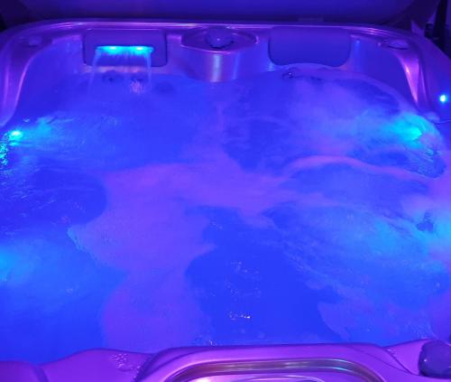 a hot tub with purple and blue fluids at Paradis Secret Spa in Damprichard