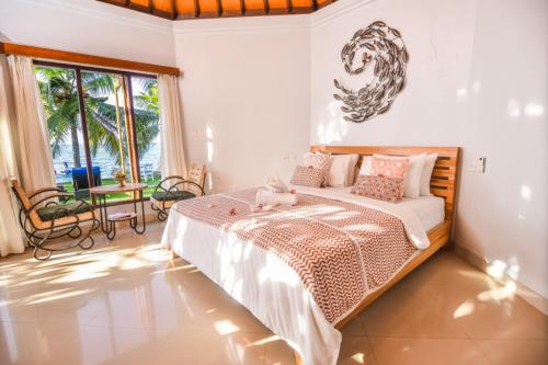 a bedroom with a bed with a teddy bear on it at Mojito Beach Villas in Kubutambahan