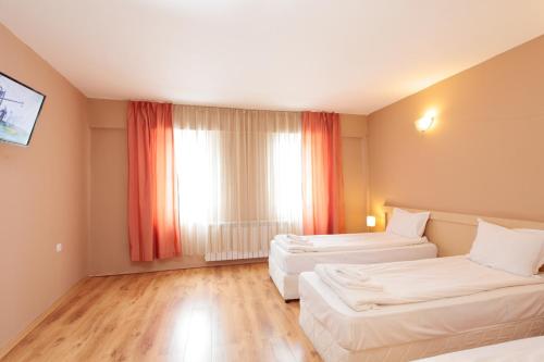 a hotel room with two beds and a window at Hotel Panorama in Panichishte