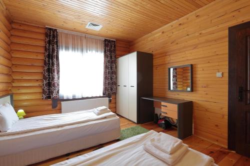 a bedroom with two beds and a window and a desk at Hotel Panorama in Panichishte