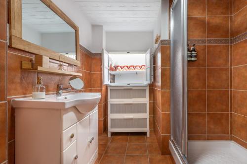 a bathroom with a sink and a mirror at Casa Randonneur, traditional townhouse in Álora. in Alora