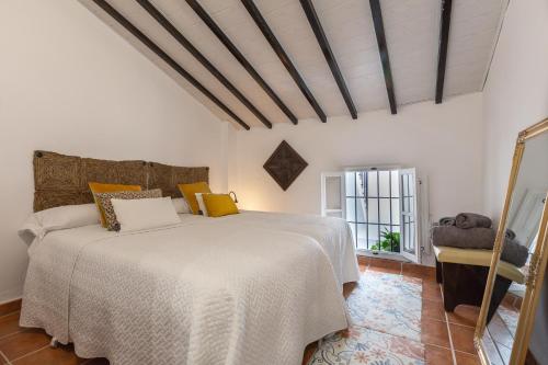 um quarto com uma cama branca e uma janela em Casa Randonneur, traditional townhouse in Álora. em Álora