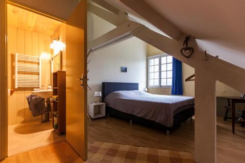 una camera con letto in una camera con mansarda di Les Cavaleries a Nonards
