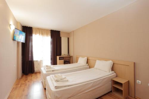 a hotel room with two beds and a television at Hotel Panorama in Panichishte