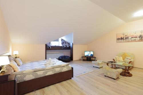 a bedroom with a large bed and a living room at Hotel Panorama in Panichishte