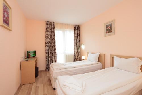 two beds in a room with a window at Hotel Panorama in Panichishte