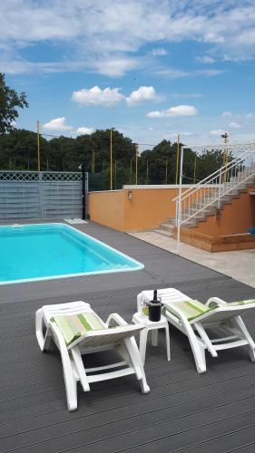 two chairs and a table and a swimming pool at The Olive Garden in Šibenik