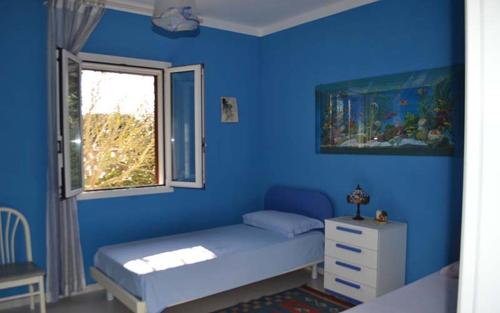 una camera da letto blu con un letto e una finestra di Villa con piscina - Pt54 a Torre dell'Orso