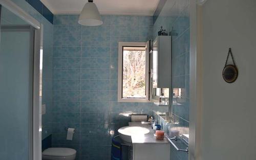 un bagno con lavandino, WC e finestra di Villa con piscina - Pt54 a Torre dell'Orso