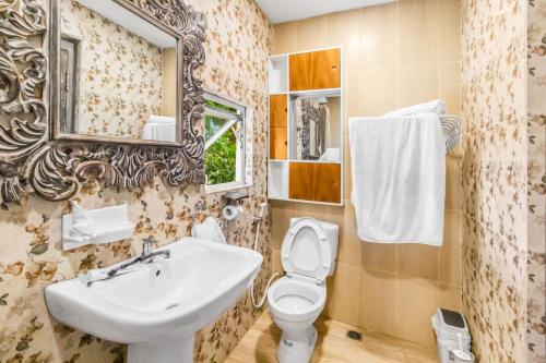 uma casa de banho com um lavatório, um WC e um espelho. em Colibry em Sanur