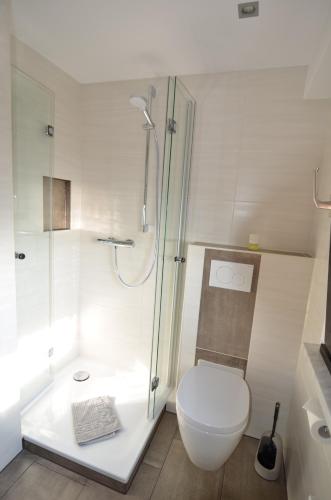 a white bathroom with a toilet and a shower at Ferienwohnung Bouten B in Geldern