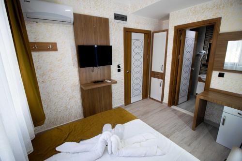 Ersoy İkiz Otel في أنطاليا: غرفة نوم مع سرير وتلفزيون على الحائط