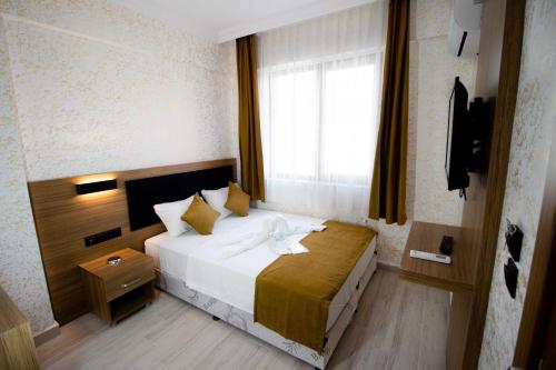 a hotel room with a bed and a window at Ersoy İkiz Otel in Antalya