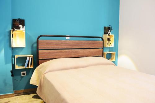 Bett in einem Zimmer mit blauer Wand in der Unterkunft Athens city Poppy's Dreamy Apartment, Thissio in Athen