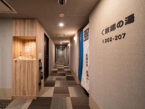 a corridor of a hospital with a sign on the wall at Super Hotel Higashi-Maizuru in Maizuru