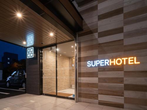 a superhotel sign on the side of a building at Super Hotel Higashi-Maizuru in Maizuru