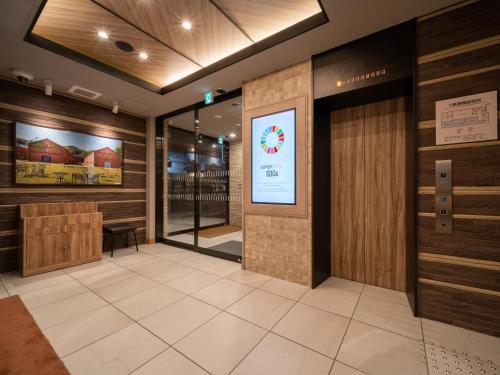 a lobby of a restaurant with a revolving door at Super Hotel Higashi-Maizuru in Maizuru